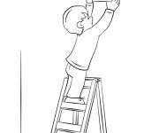 Coloriage Gar&ccedil;on accroche une photo sur le mur