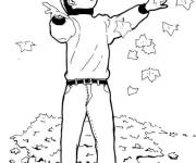 Coloriage Gar&ccedil;on en jouant avec les feuilles d'automne